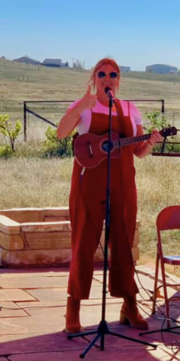 Sarah playing the ukulele at a jacob center fundraiser